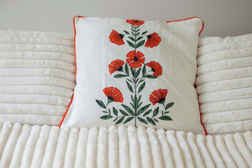 Close-up of floral pillow and bed linens – Soft textures and inviting design details.