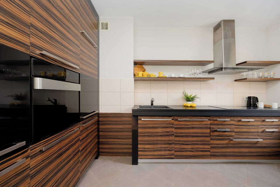 Modern kitchen with wooden finishes – Fully equipped kitchen with oven, stove, and dining area.
