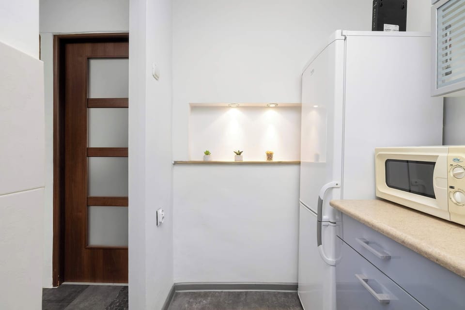 Light-colored kitchen with plenty of cabinets, toaster, microwave, and built-in oven.