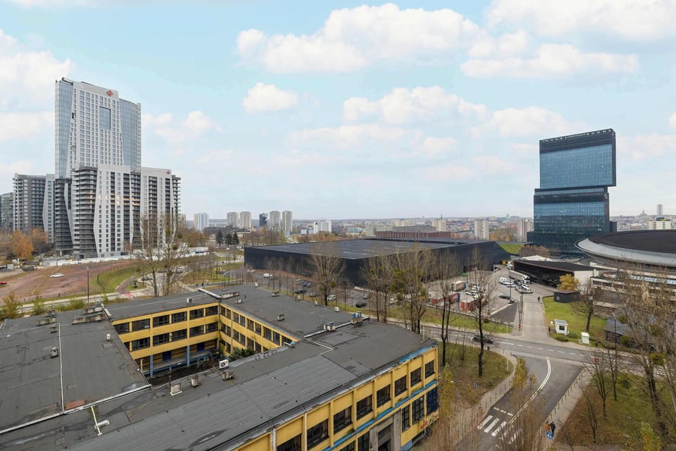 Cityscape view showing tall buildings and a busy street from above.