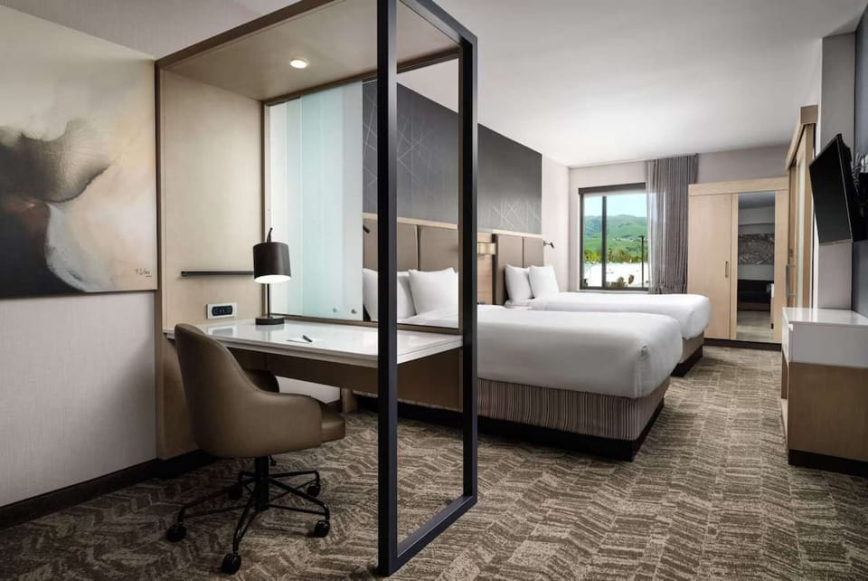 Twin beds and desk with mountain view through large window