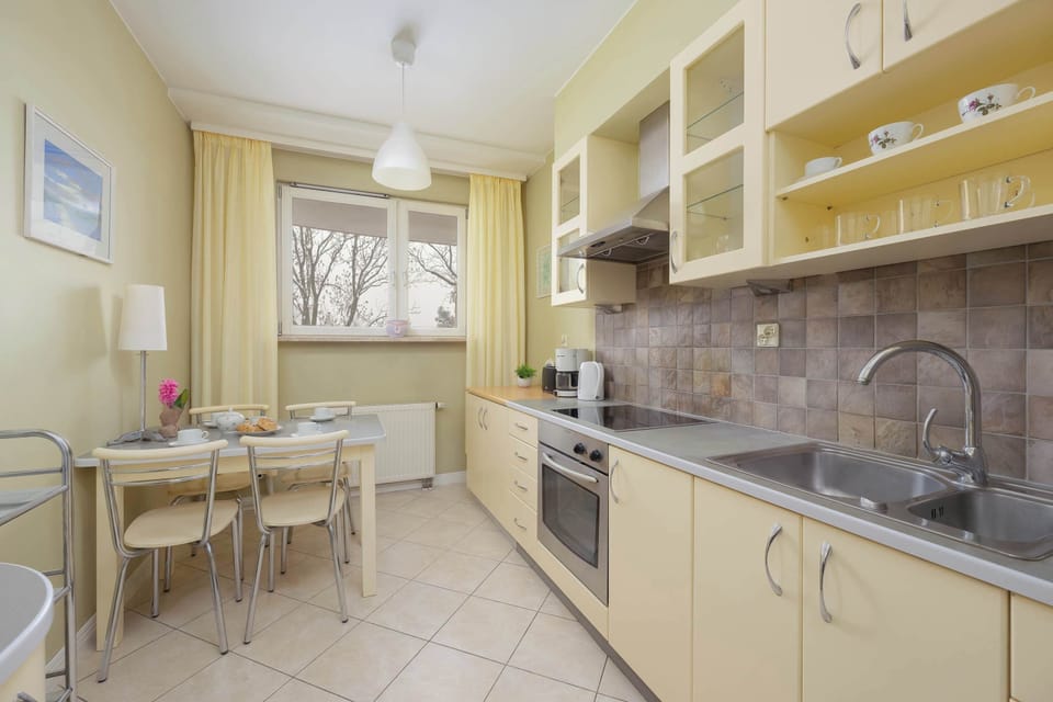 Functional kitchen with light cabinetry, tiled backsplash, built-in oven, and generous storage.