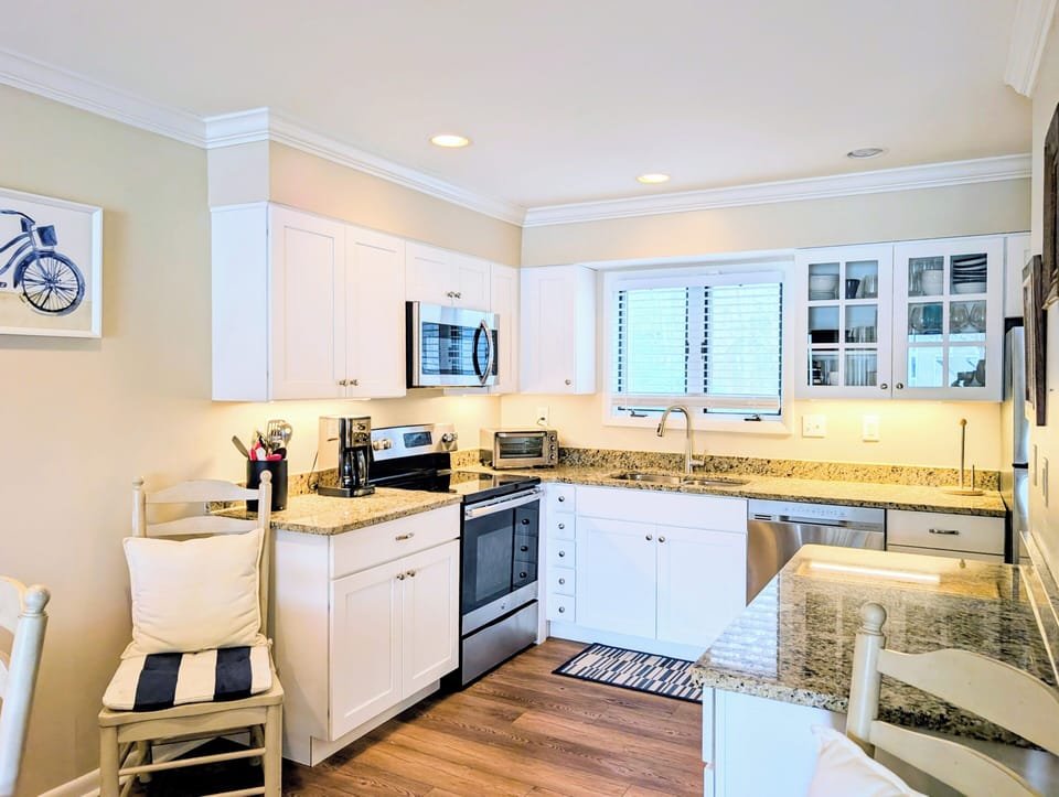 4006 Brighton Trail, sea Colony West - kitchen - Bright kitchen featuring white cabinetry, granite countertops, and stainless steel appliances.