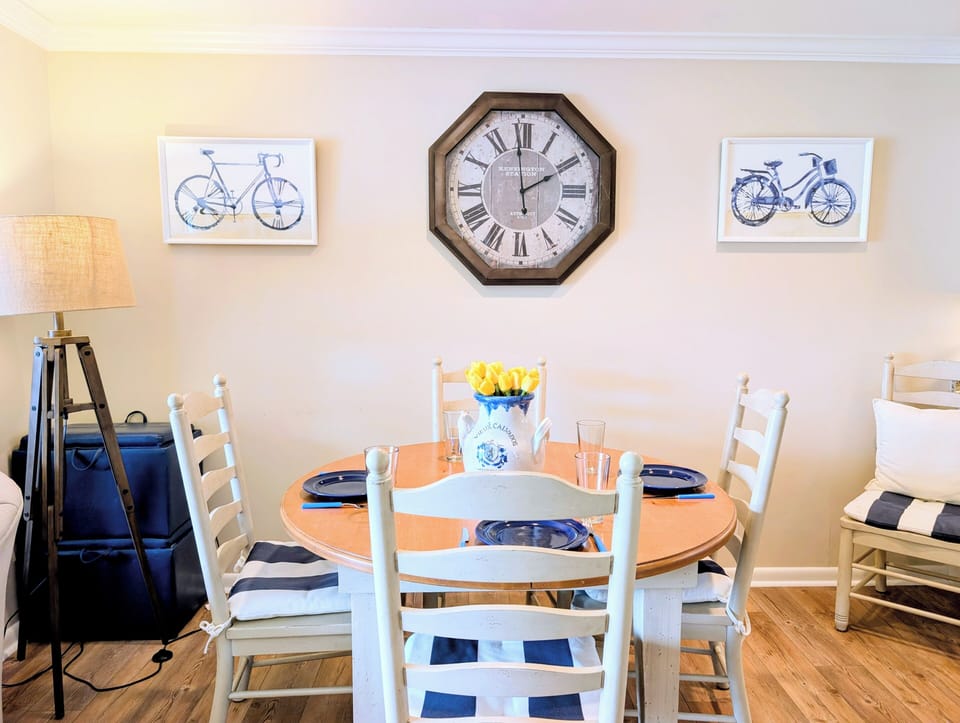 4006 Brighton Trail, sea Colony West - Dining table - View of the coastal-themed dining set with a large decorative wall clock and striped chair cushions.