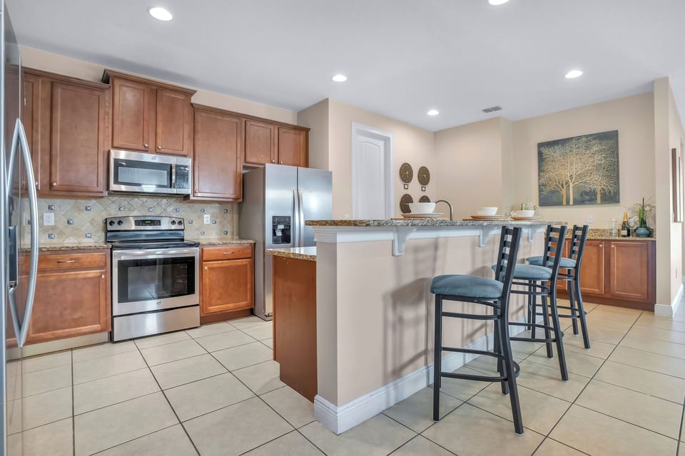 Fully equipped kitchen w/ stainless steel appliances & breakfast bar seating