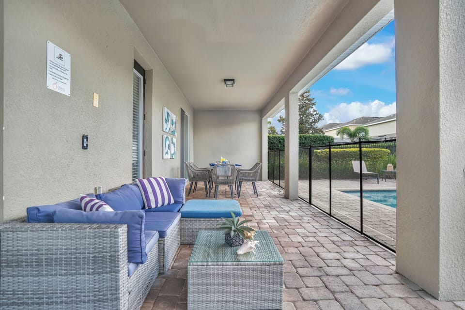 Covered patio w/ cozy seating & dining area, ideal for shaded outdoor lounging