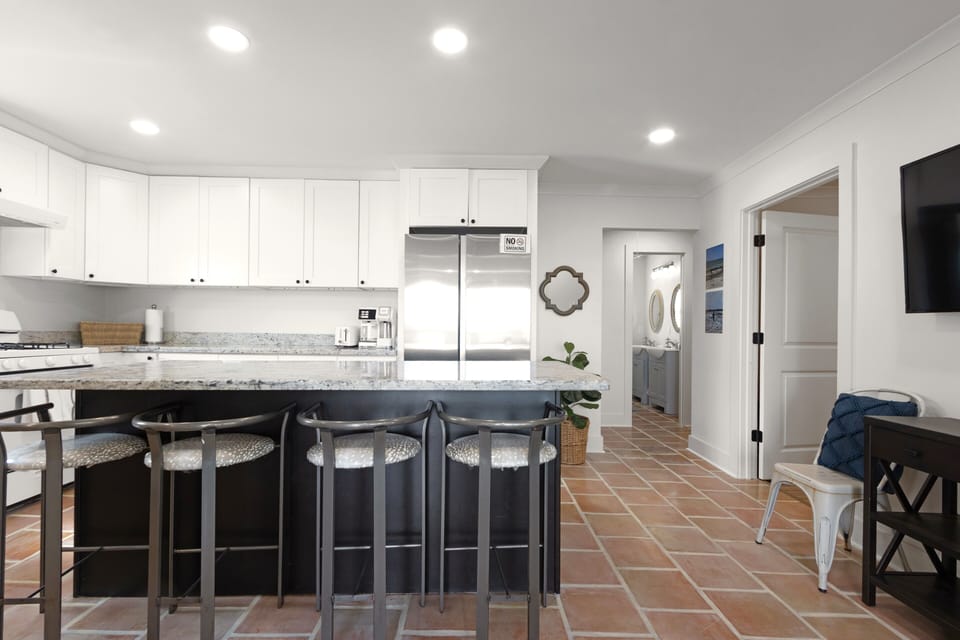 Sunlit kitchen featuring granite countertops and casual island seating