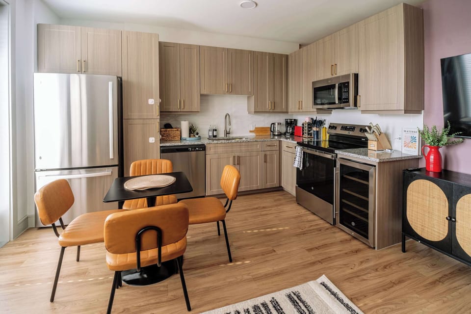 Bright open kitchen and dining area featuring modern appliances, stylish cabinetry, and comfortable seating. Perfect for home cooked meals, shared breakfasts, or relaxing evenings while enjoying the spacious layout.