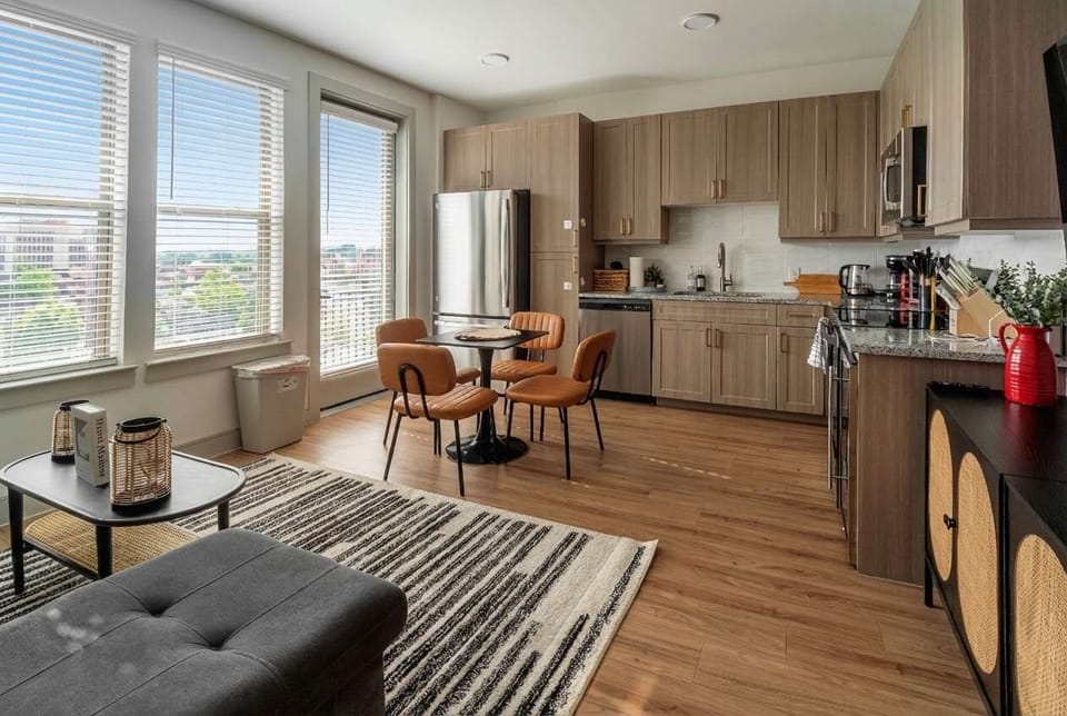 Open concept living and dining space with a fully equipped kitchen, contemporary cabinetry, and cozy seating. Large windows create an airy feel, making this the perfect spot for cooking, dining, or unwinding together during your stay.