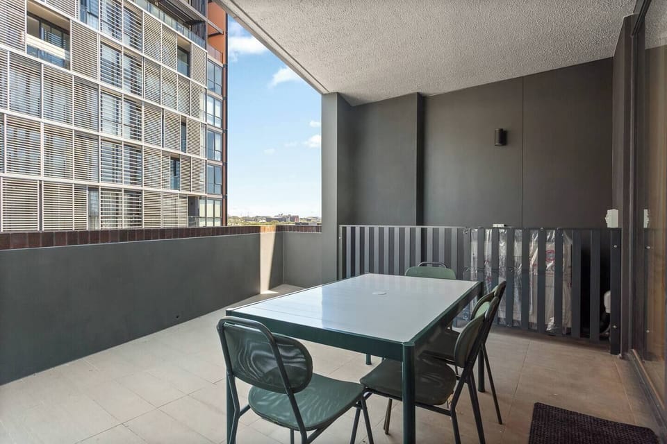 Enjoy relaxed meals or morning coffee on the spacious balcony, where outdoor dining and open skies create an easy extension of the living space.