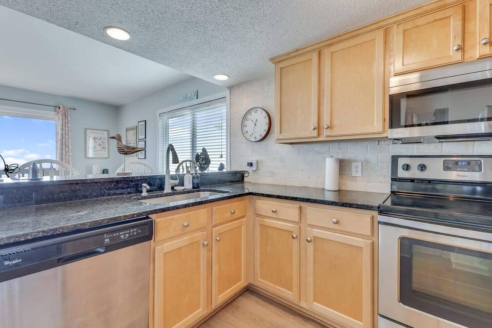 Your fully equipped kitchen features warm maple cabinets, granite counters, and stainless appliances—perfect for preparing memorable meals during your stay.