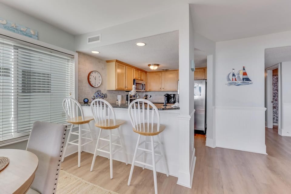 Your open kitchen flows seamlessly into the dining area, where coastal charm meets modern convenience for memorable meal preparations.