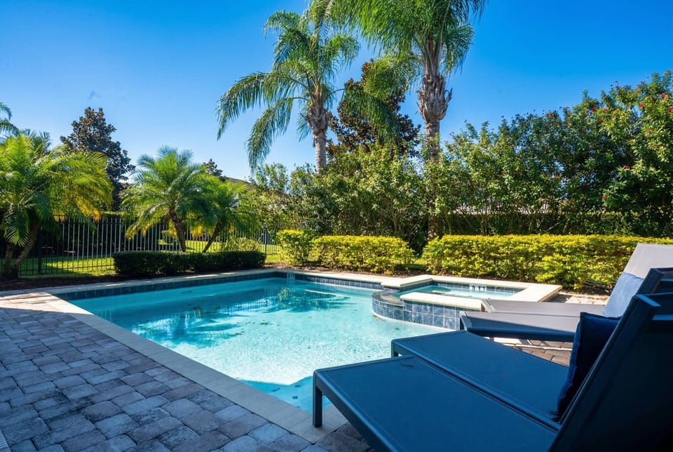Step outside to enjoy a stunning pool area surrounded by vibrant palm trees and lush greenery. The inviting lounge chairs are perfect for soaking up the sun and unwinding in this serene paradise.
