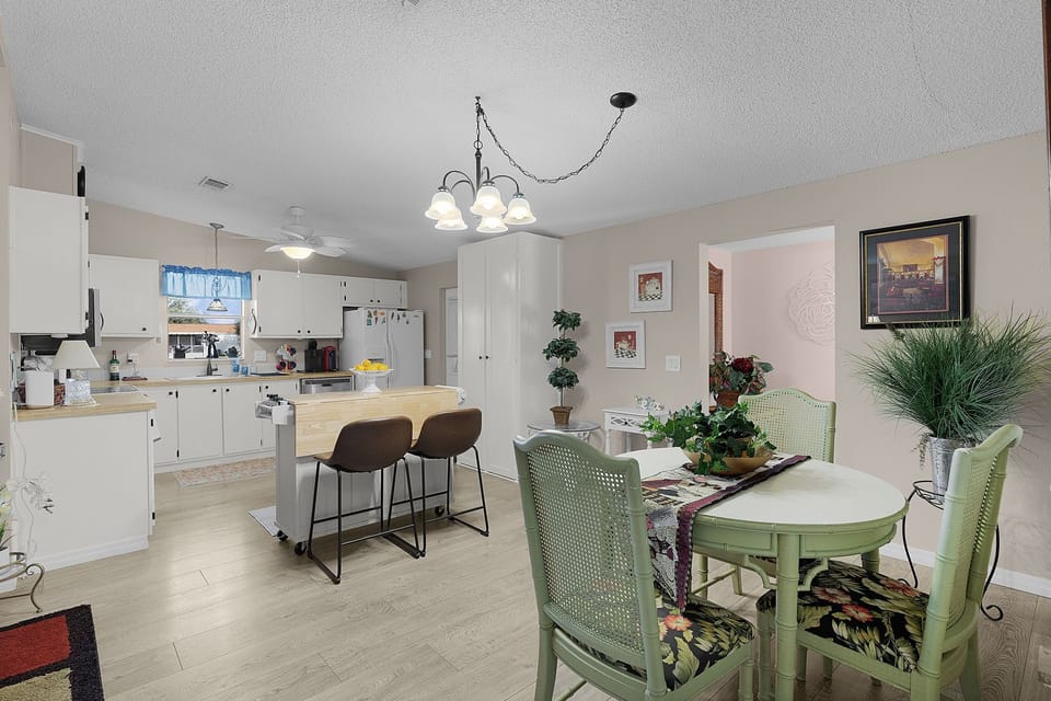Your open-concept kitchen and dining space features white cabinets, modern appliances, and a breakfast bar for casual meals together.
