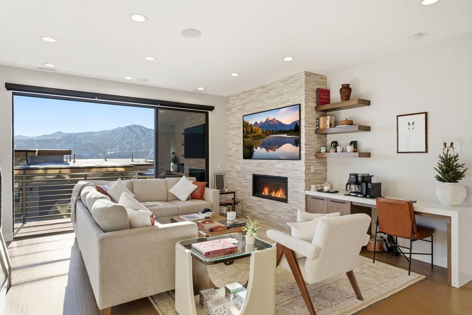 Bright living room with fireplace and mountain views
