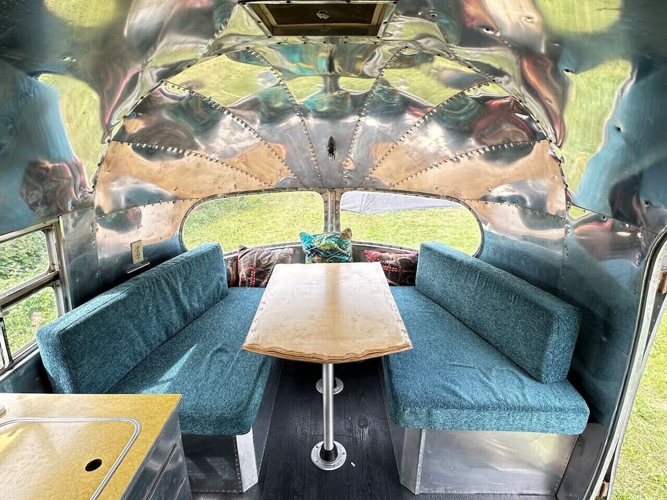 Retro dining booth wrapped in polished aluminium curves.