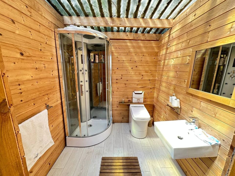Cedar-lined shared bathroom with a hydro shower.