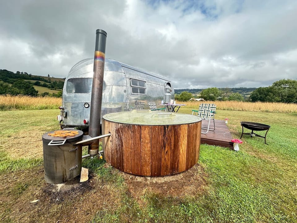 Wood-fired tub heats up beside the Airstream on a moody afternoon.