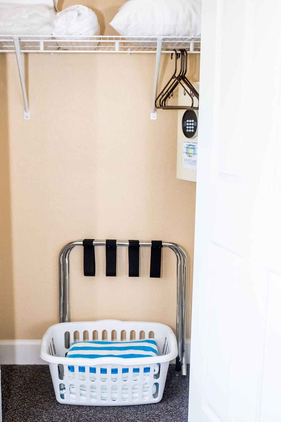 A neat closet area with shelves, hangers, and a laundry basket for organized storage.