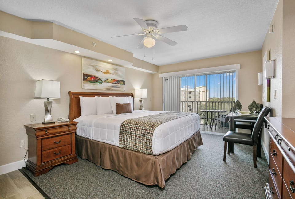 comfortable hotel room featuring a king bed, soft linens, and warm ambient lighting.