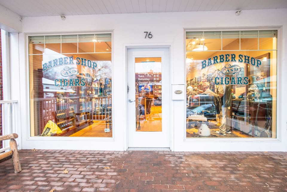 The quaint Barber Shop and Cigars storefront reflects the local community's unique flair, adding to the inviting charm.