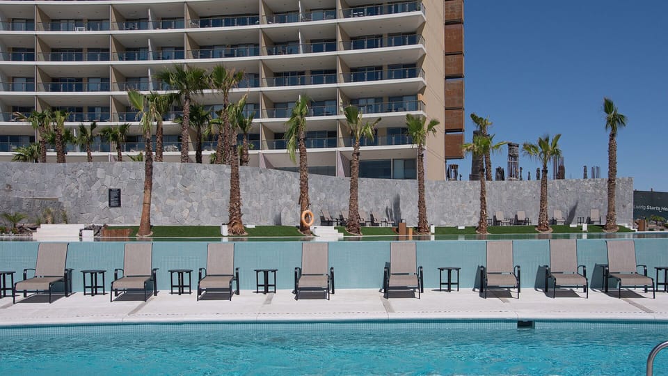 Chaise lounge chairs line the negative edge pool