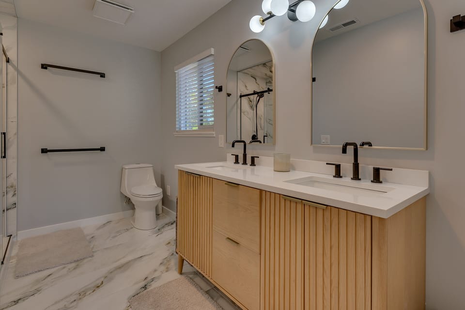 Bathroom w/ Dual Sinks and Glass-Enclosed Shower