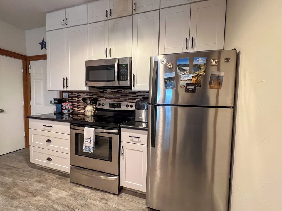 Full kitchen with glassware, cooking utensils, small appliances, pans, dishes