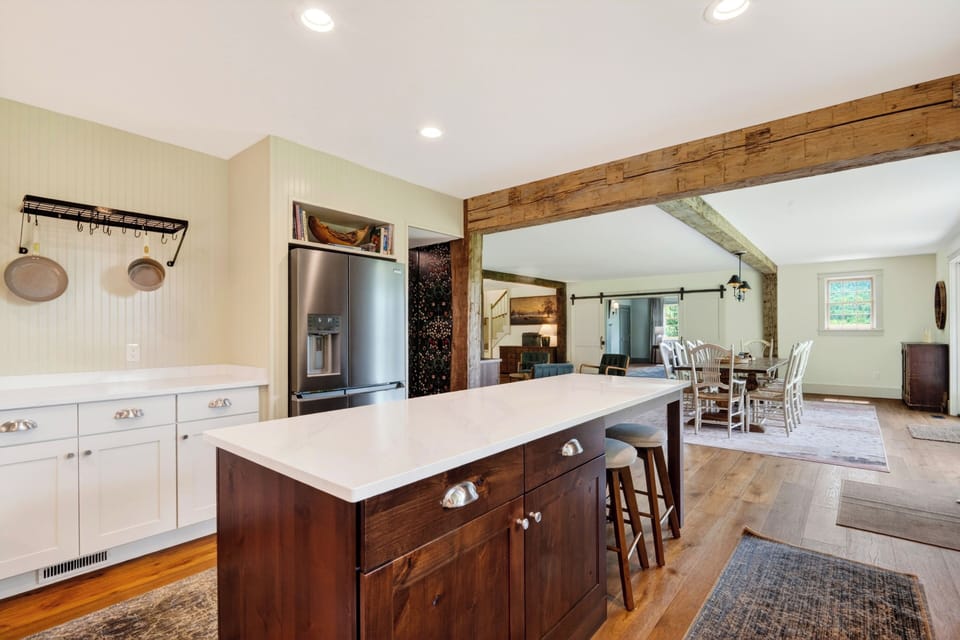 Bright farmhouse kitchen with a large island, rustic beam details, and plenty of space for group cooking.