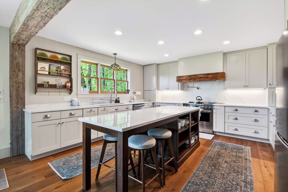 Bright farmhouse kitchen with a large island, rustic beam details, and plenty of space for group cooking.