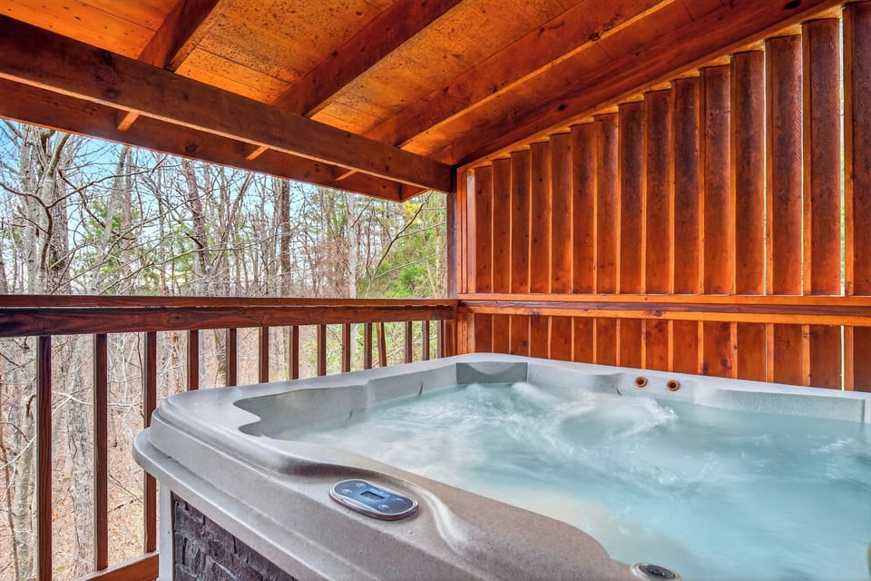 Private covered deck with a relaxing hot tub and forest views.