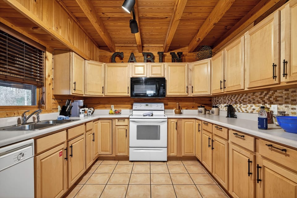 Fully equipped kitchen with wrap-around cabinetry and modern white appliances.