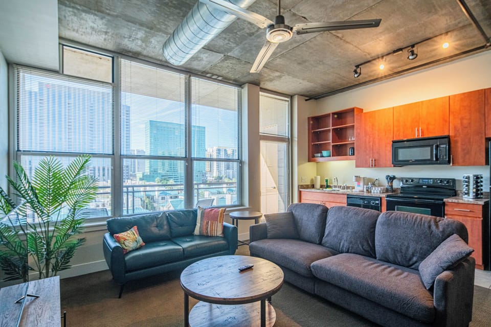 Relax in your modern loft with soaring ceilings, exposed concrete, and floor-to-ceiling windows framing stunning city views.