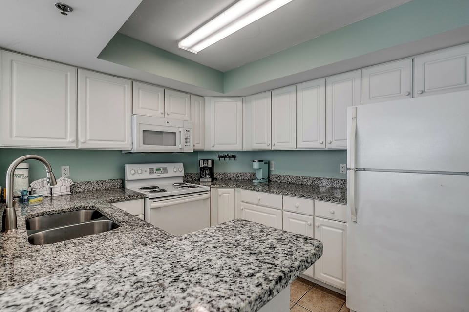 Large kitchen with ample counter space and all necessary amenities including a refrigerator, freezer, oven/stovetop, microwave, and more!