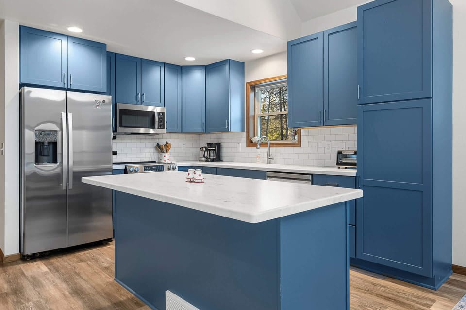 Cook your favorite meals in this stunning blue kitchen with modern appliances and spacious counters for easy meal prep.