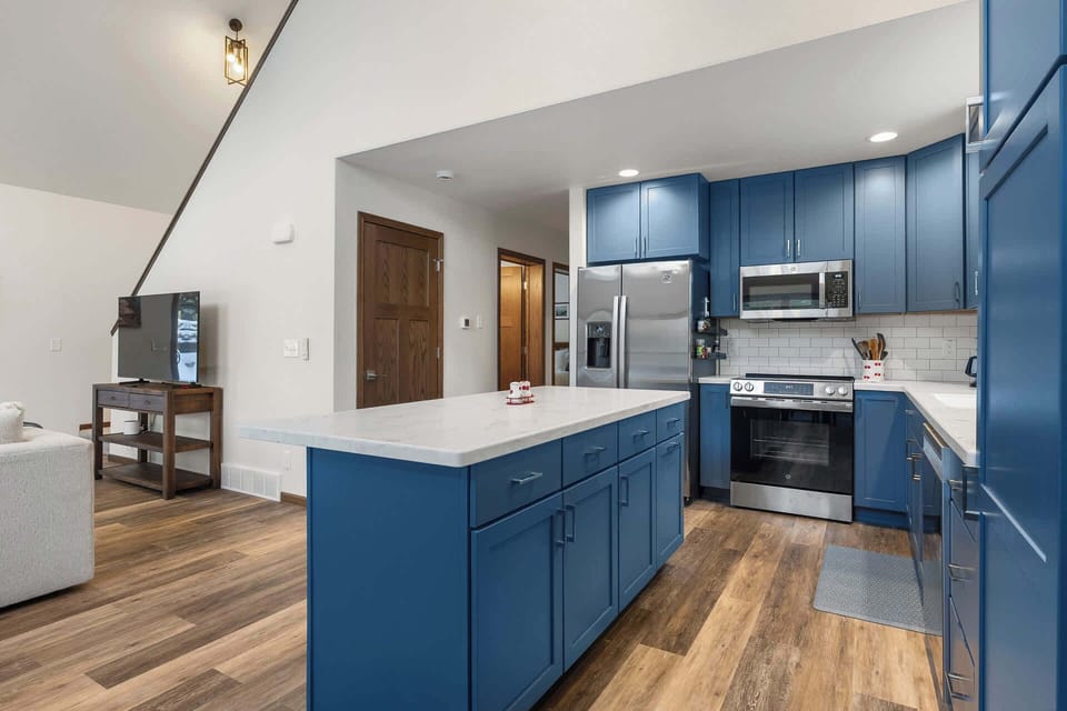 Your stylish kitchen features rich blue cabinetry, granite counters, and stainless steel appliances for memorable meal preparation.
