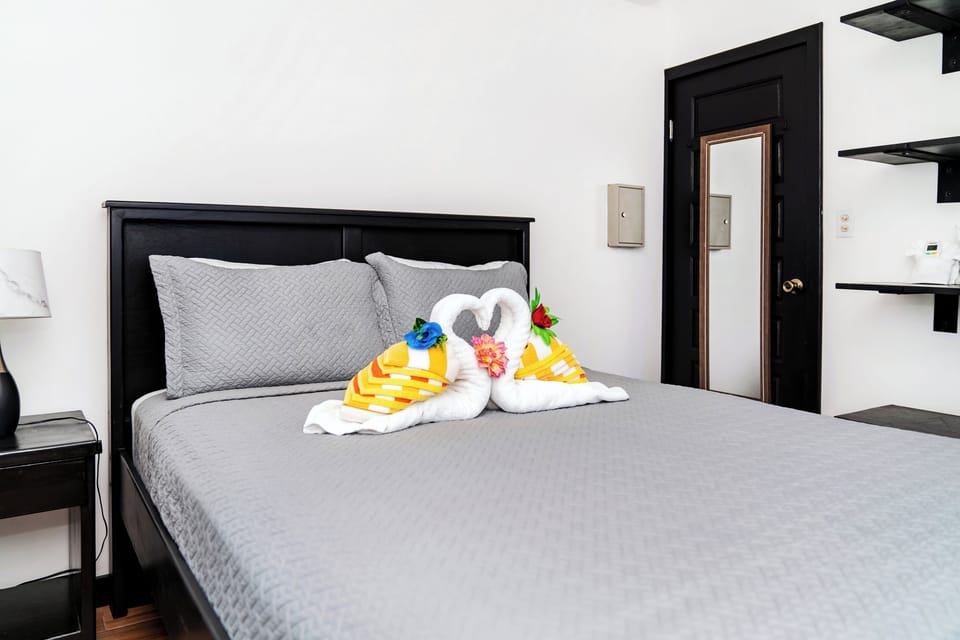 Unwind in your cozy bedroom with plush bedding, thoughtful touches like towel swans, and smart storage shelving for all your belongings.