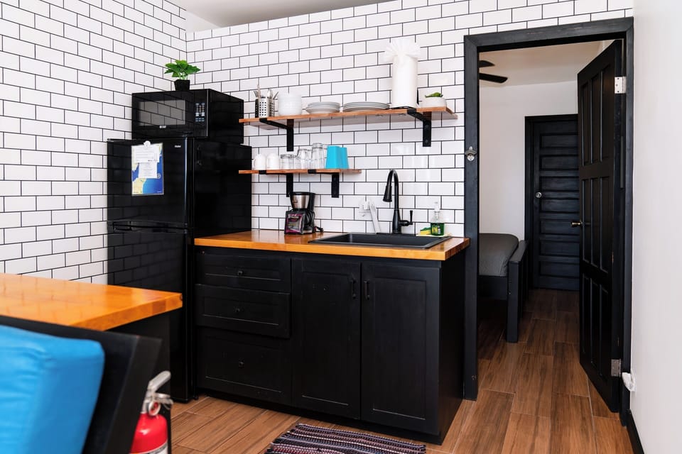 Kitchenette with fridge, coffee maker, microwave, sink & hot plate