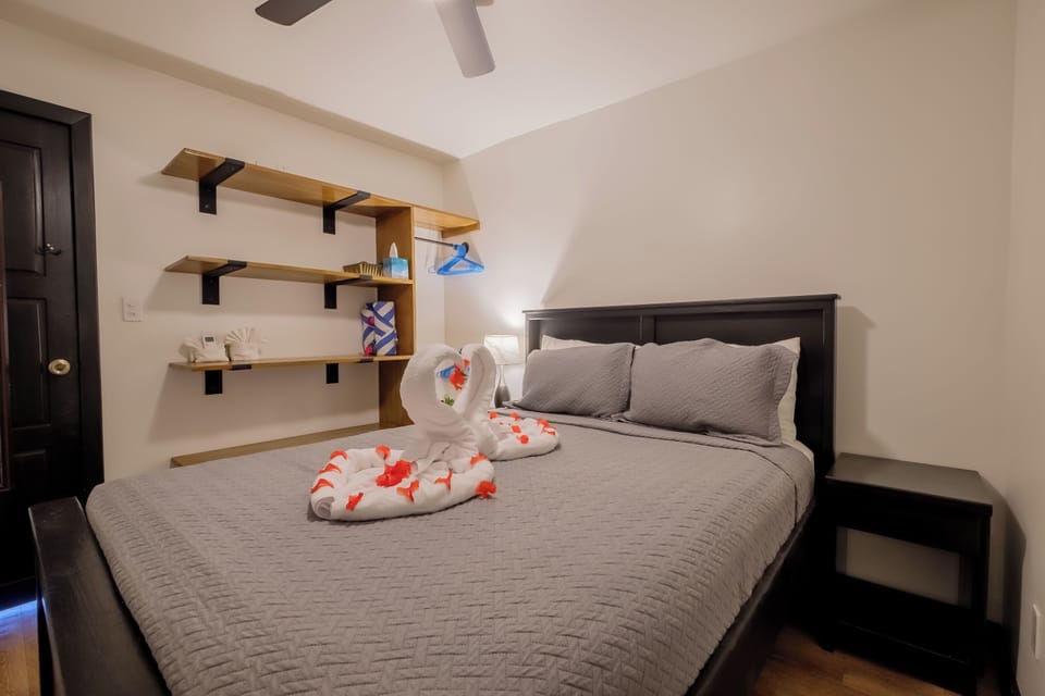 Your cozy bedroom retreat features a comfortable queen bed and smart storage shelves.