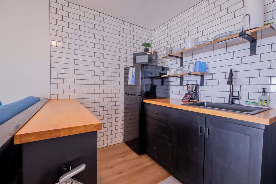 Kitchenette with fridge, coffee maker, microwave, sink & hot plate