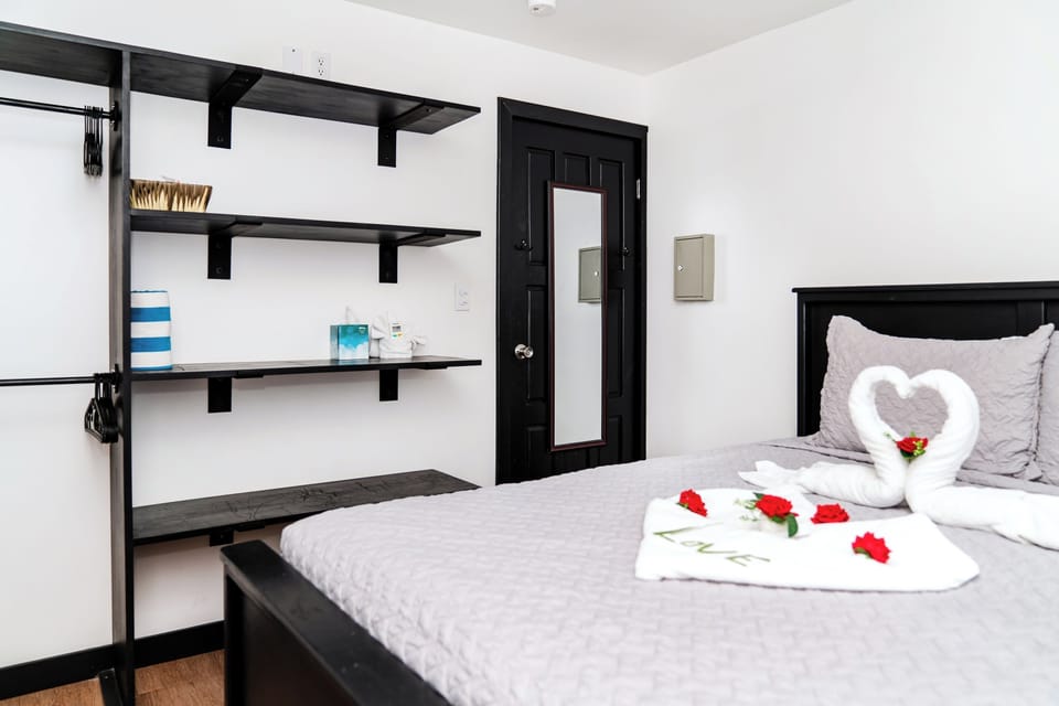 Queen bed with open shelving for essentials, and plush linens.