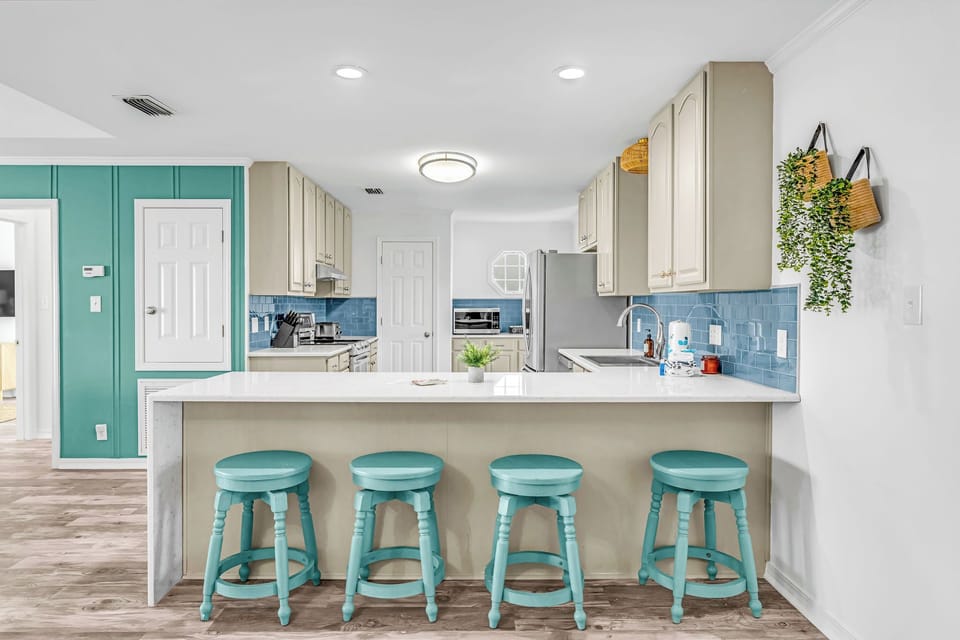 Open style kitchen, bar seating, and everything you'd need to prepare a meal.
