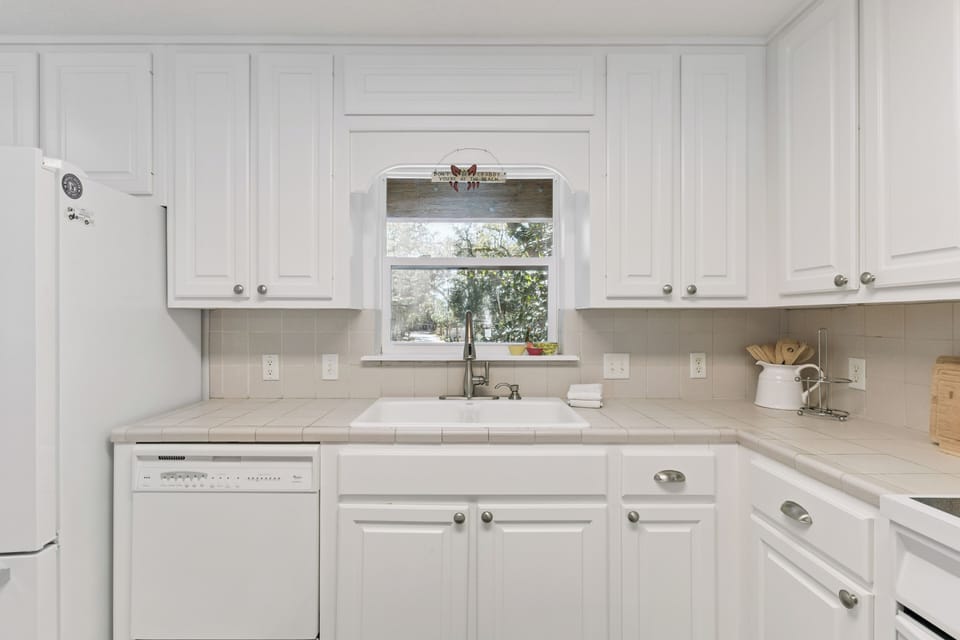 Your bright white kitchen offers everything needed for meal prep, with a charming window view to brighten your cooking experience.
