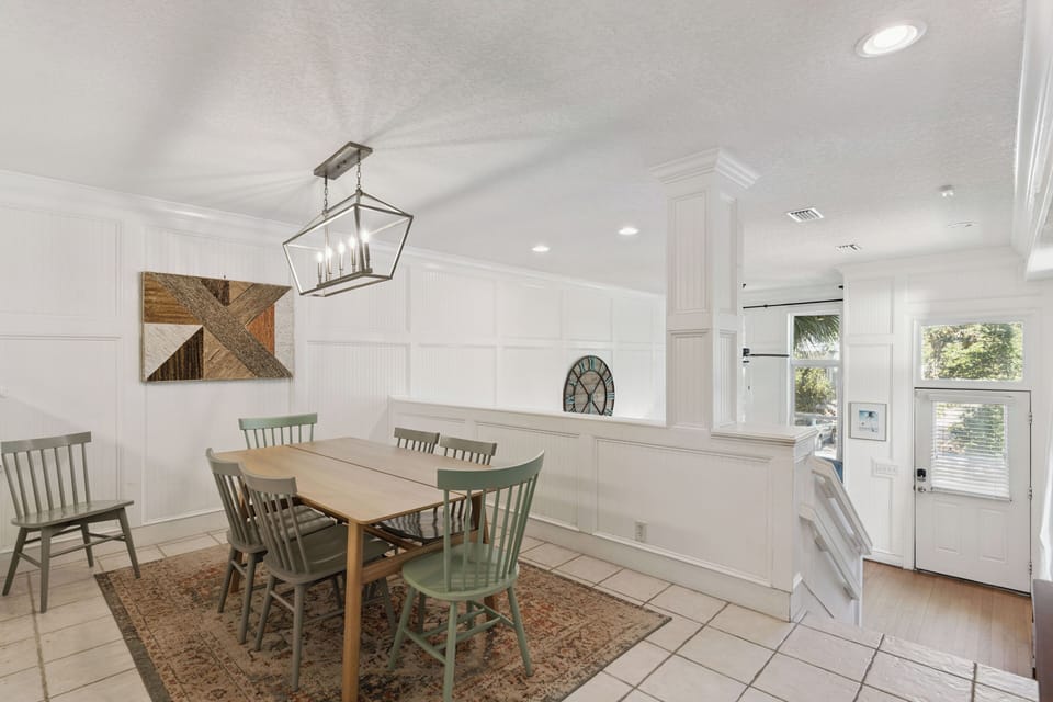Gather around your elegant dining table where sage-green chairs and a charming lantern create the perfect setting for memorable meals together.