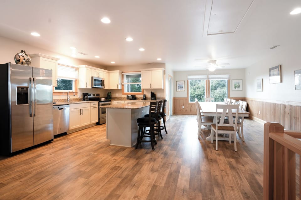 Your open-concept kitchen and dining space features gleaming appliances, granite countertops, and warm wood floors perfect for family meals and entertaining.