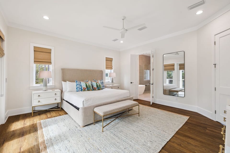 Sink into your plush upholstered bed surrounded by natural light from bamboo-dressed windows and warm hardwood floors beneath your feet.