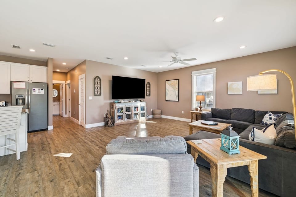 Relax in your spacious open-plan living area featuring cozy seating, modern entertainment center, and seamless flow to the fully-equipped kitchen.