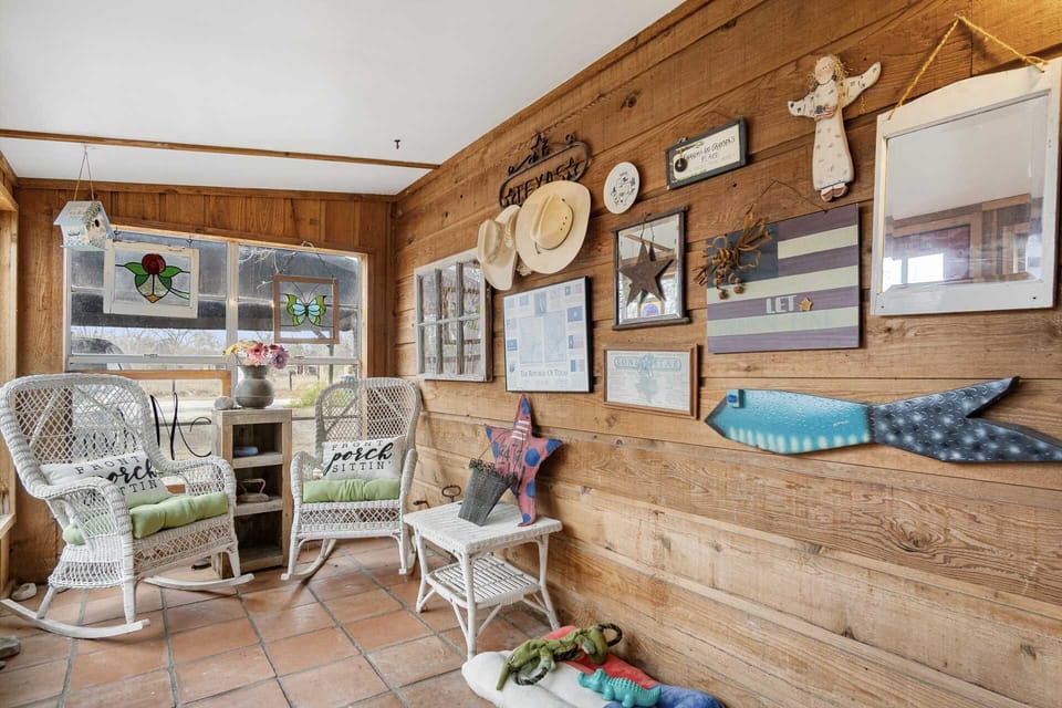 Unwind in this cozy, art-filled porch with comfy rocking chairs-an inviting spot for morning coffee, conversation, and Hill Country charm