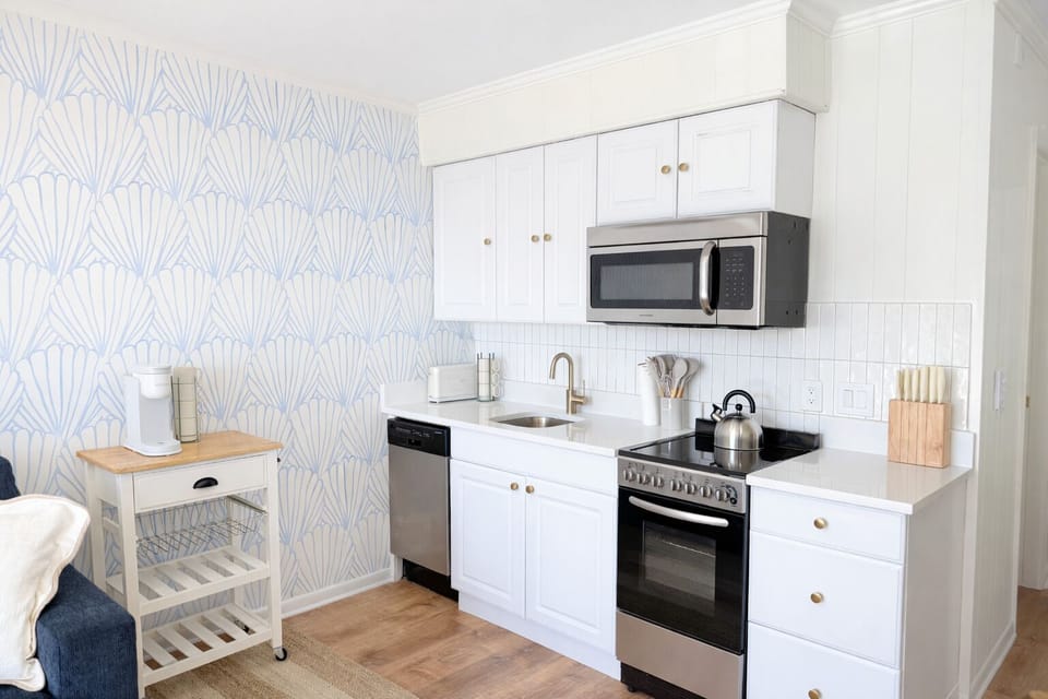 A bright, coastal kitchen with quartz countertops and stainless appliances.