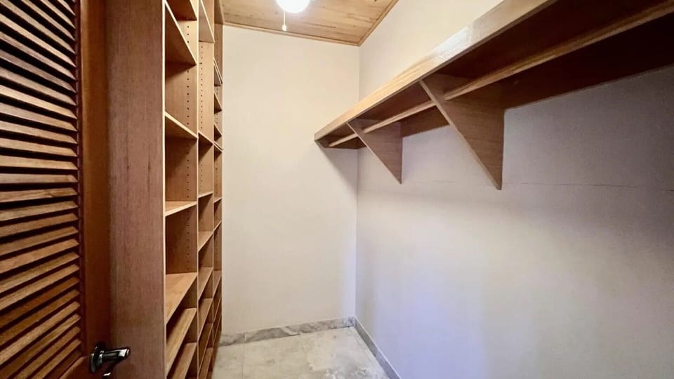 Spacious walk-in closet with built-in shelving—perfect for extended stays and unpacking.